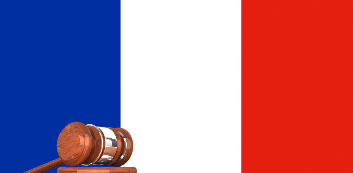 Hölzerner Richterhammer mit Flagge von Frankreich im Hintergrund