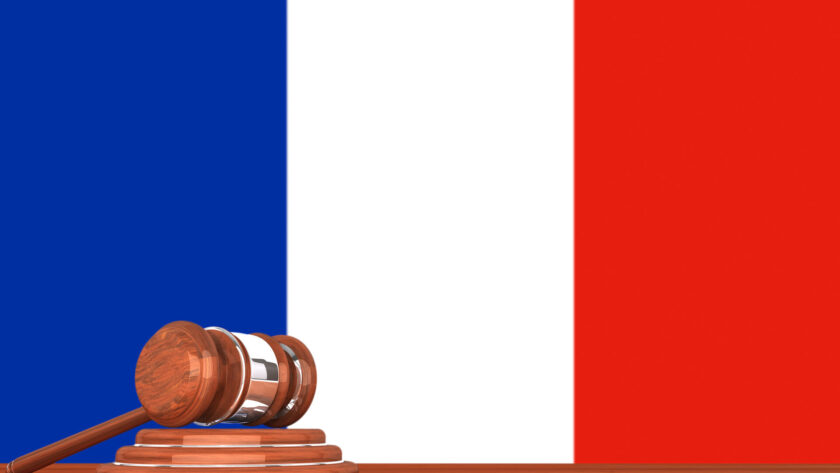 Hölzerner Richterhammer mit Flagge von Frankreich im Hintergrund