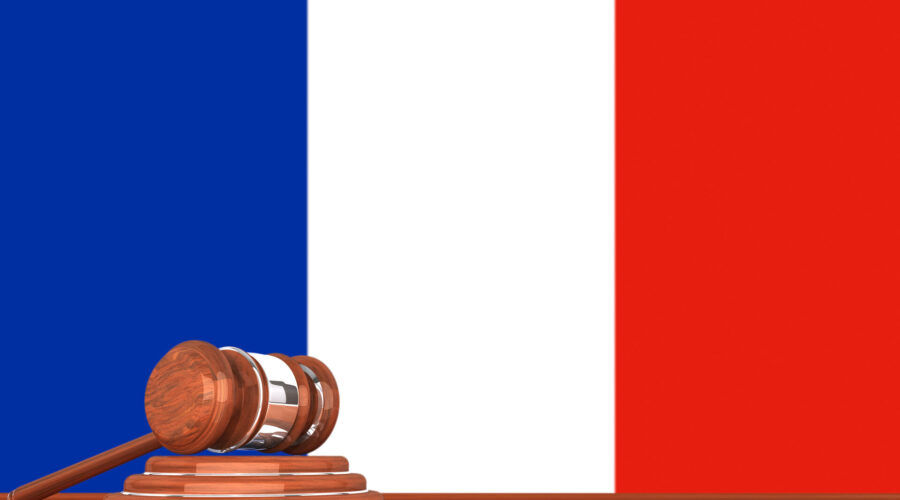 Hölzerner Richterhammer mit Flagge von Frankreich im Hintergrund