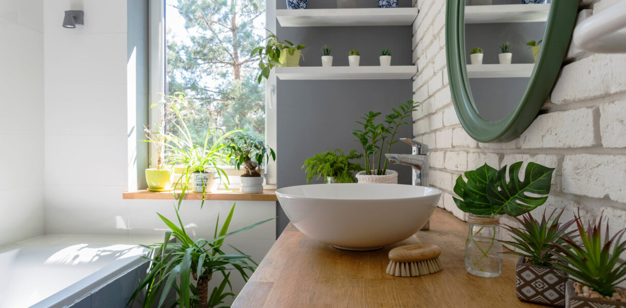 Weißes, gemütliches Badezimmer in modernem Design, mit Fenster und grünen Pflanzen.