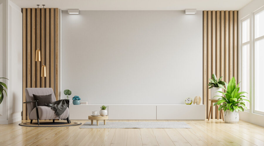 Weiße Wand in schönem, stilvollen Wohnzimmer, mit Parkettboden und mit Sessel und Accessoires.